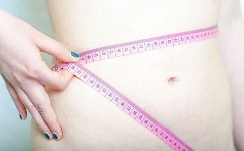 Una ragazza si misura la vita per registrare i risultati della dieta Dukan